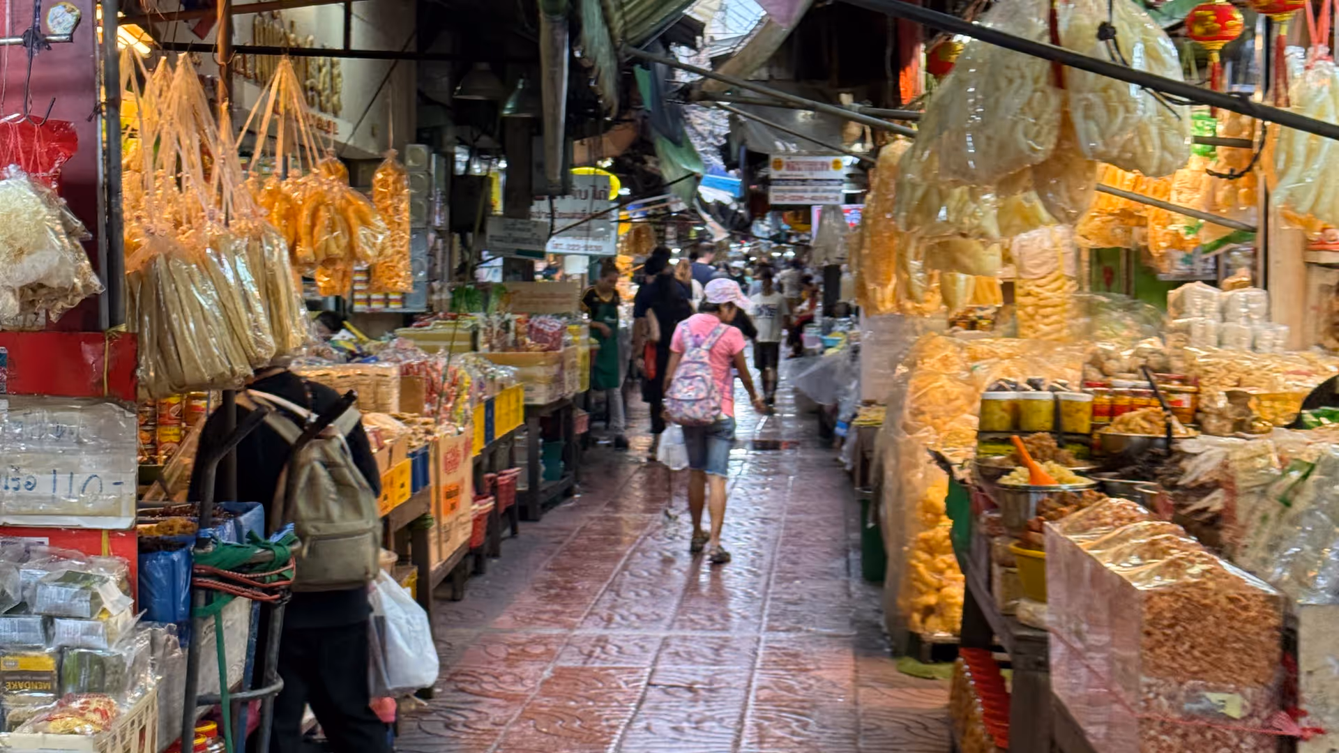 A narrow market lane in Chinatown packed with vendors and dried goods.