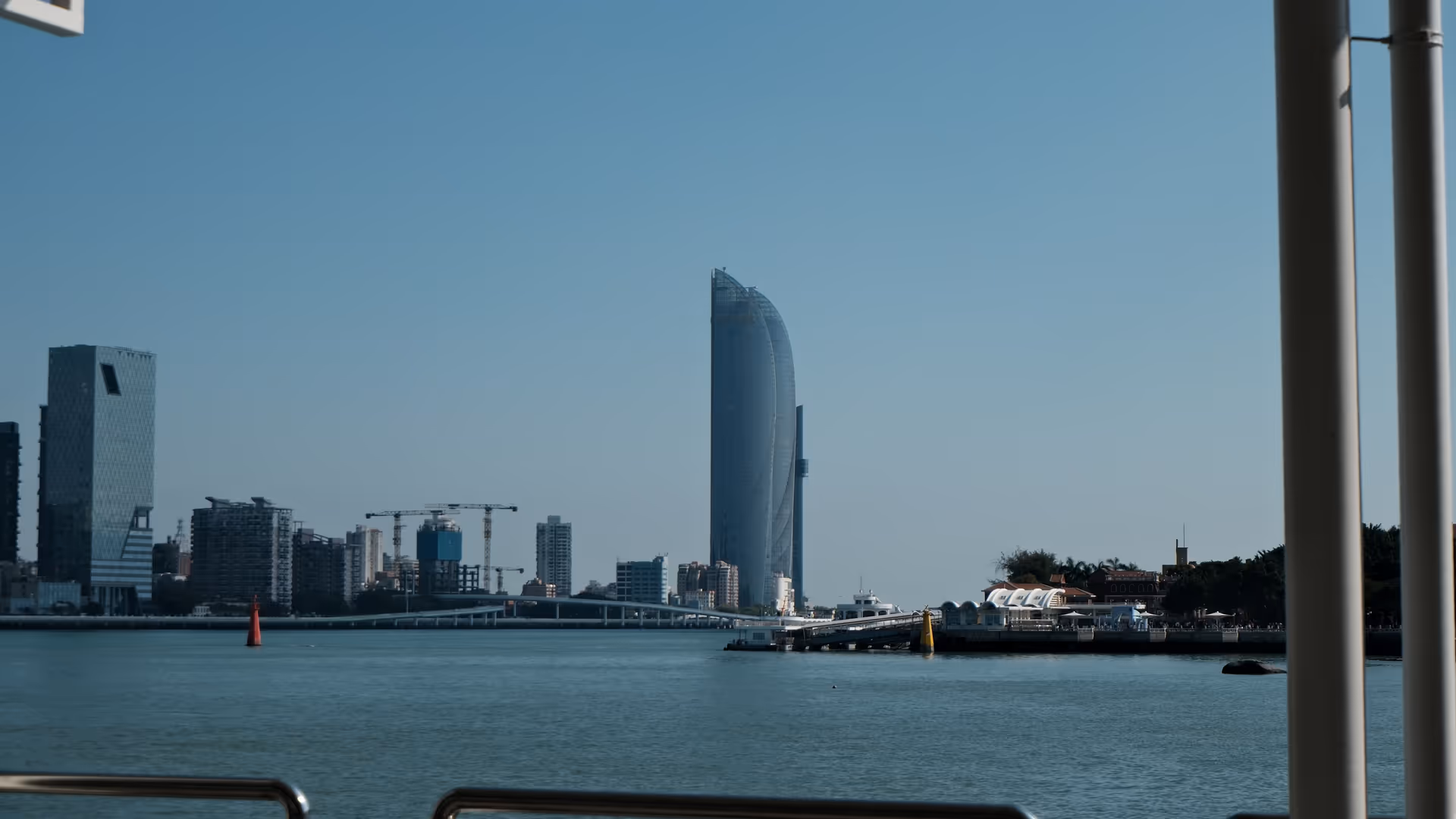 The Xiamen skyline viewed from Gulangyu harbour, a sleek curved skyscraper dominating the waterfront.