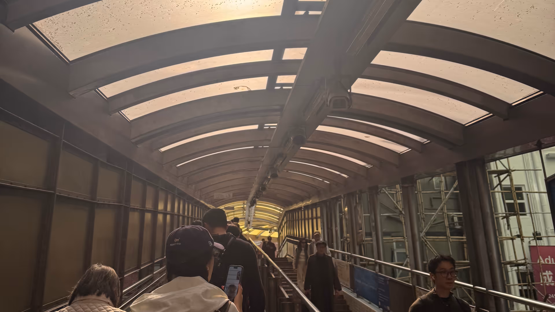 The Mid-Levels Escalator in Central, a long covered moving walkway with commuters riding through the neighbourhood.