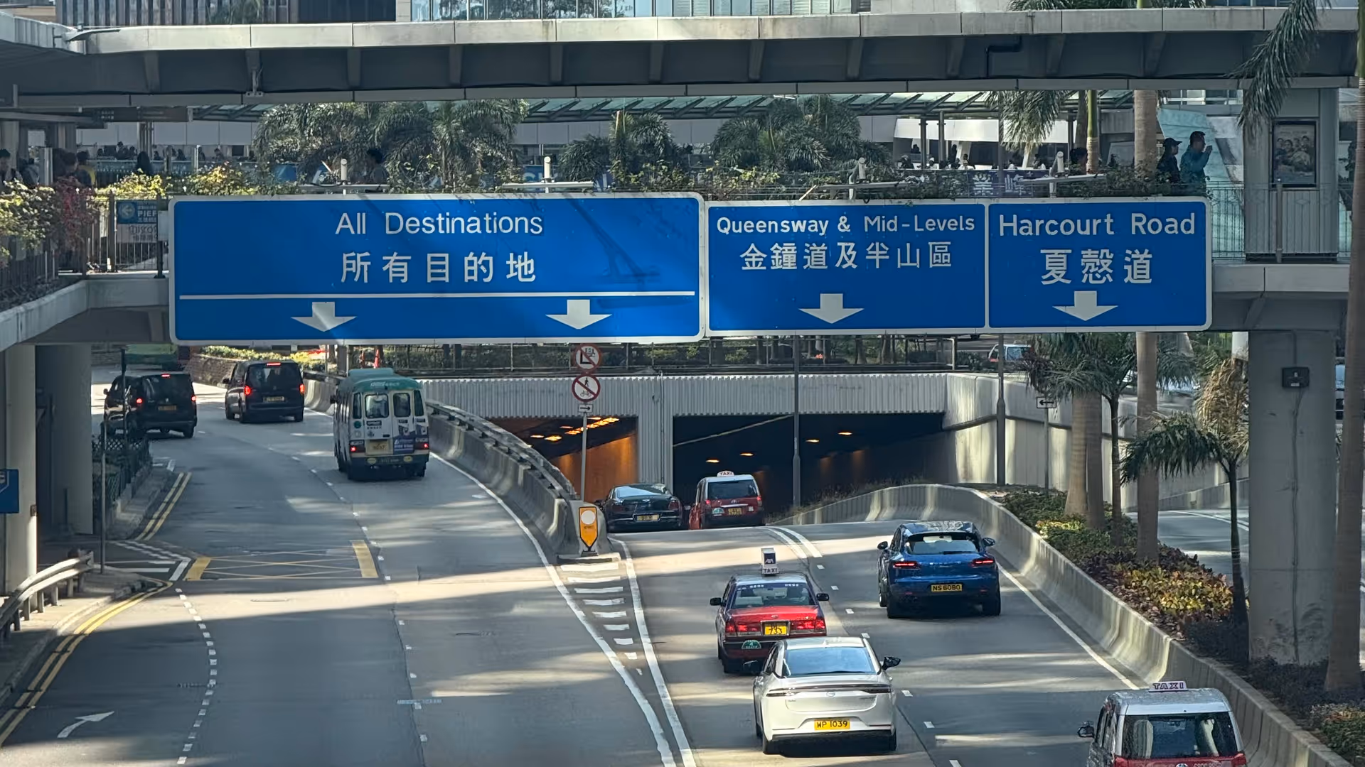 Harcourt Road in Central Hong Kong, cars flowing through a wide urban highway flanked by glass towers.