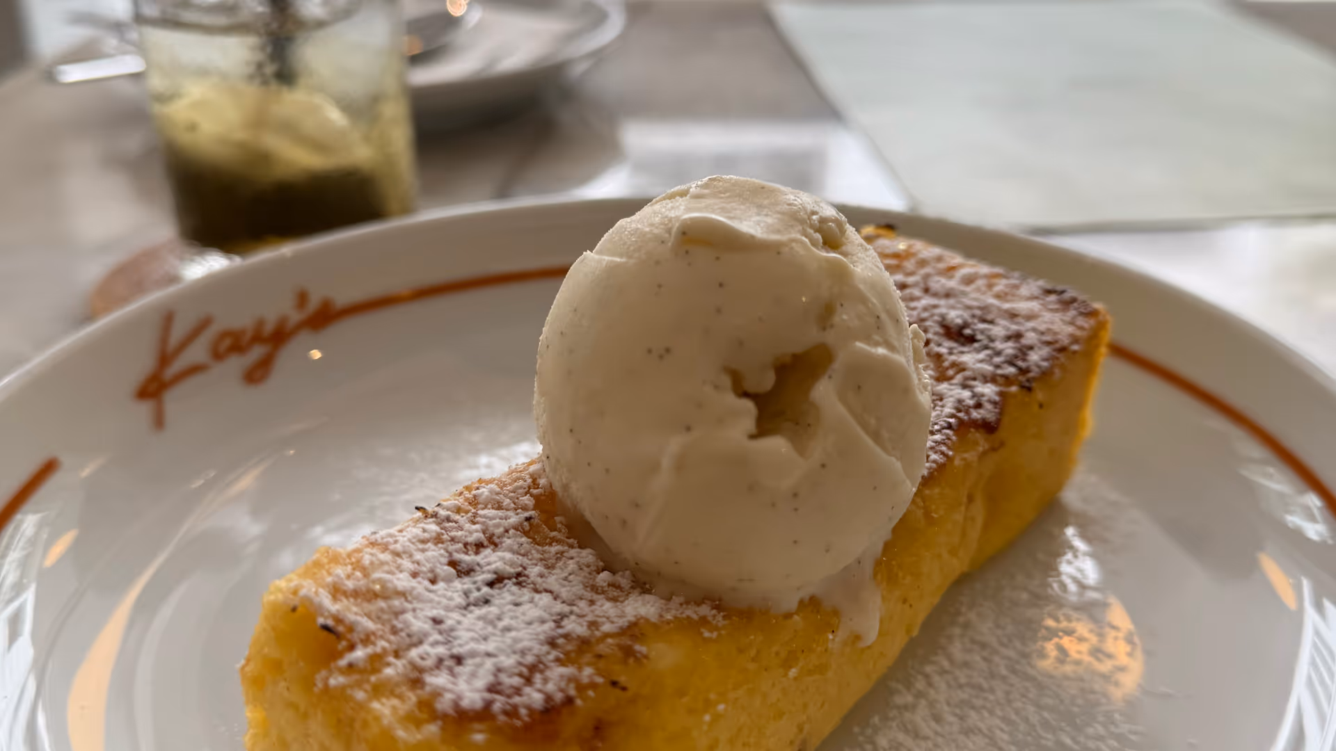 A thick slice of French toast topped with a large scoop of vanilla ice cream.