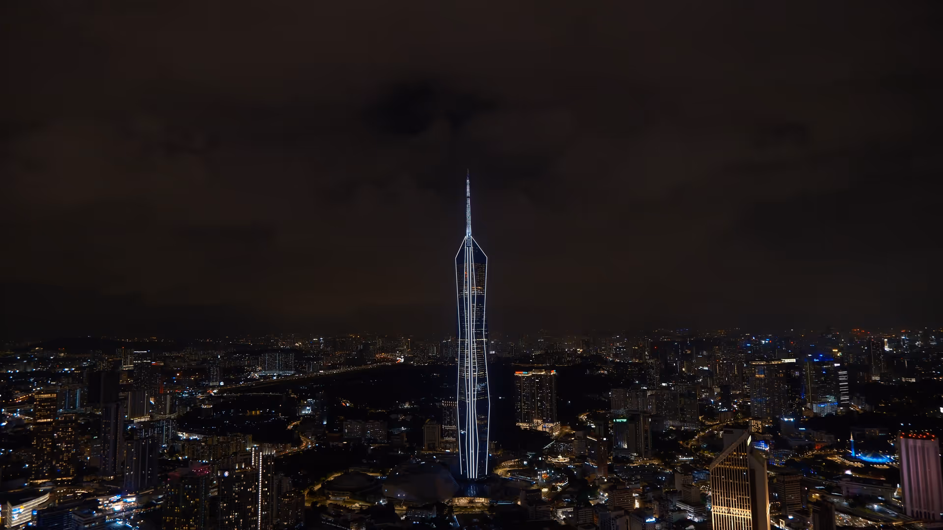 Merdeka 118 towering over the KL skyline at night, its illuminated outline cutting sharply into the dark sky.