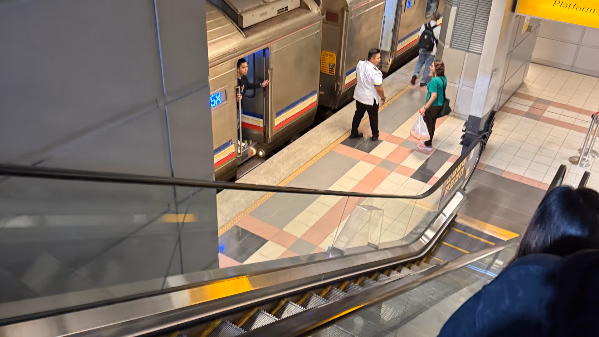 Looking down toward an intercity train waiting at a quiet, modern platform.