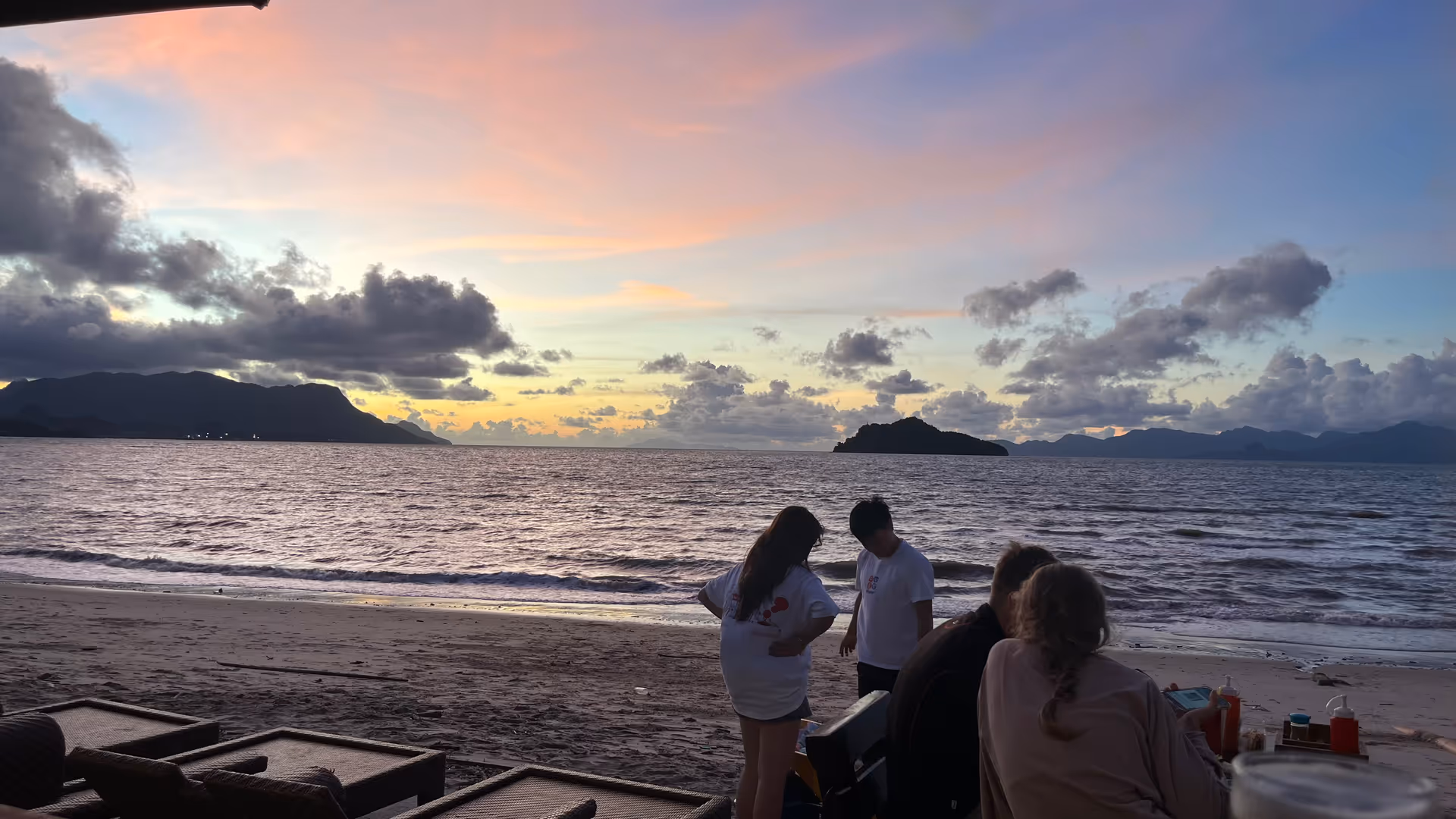 A chill beach sunset with soft purple and orange clouds reflecting over the ocean.