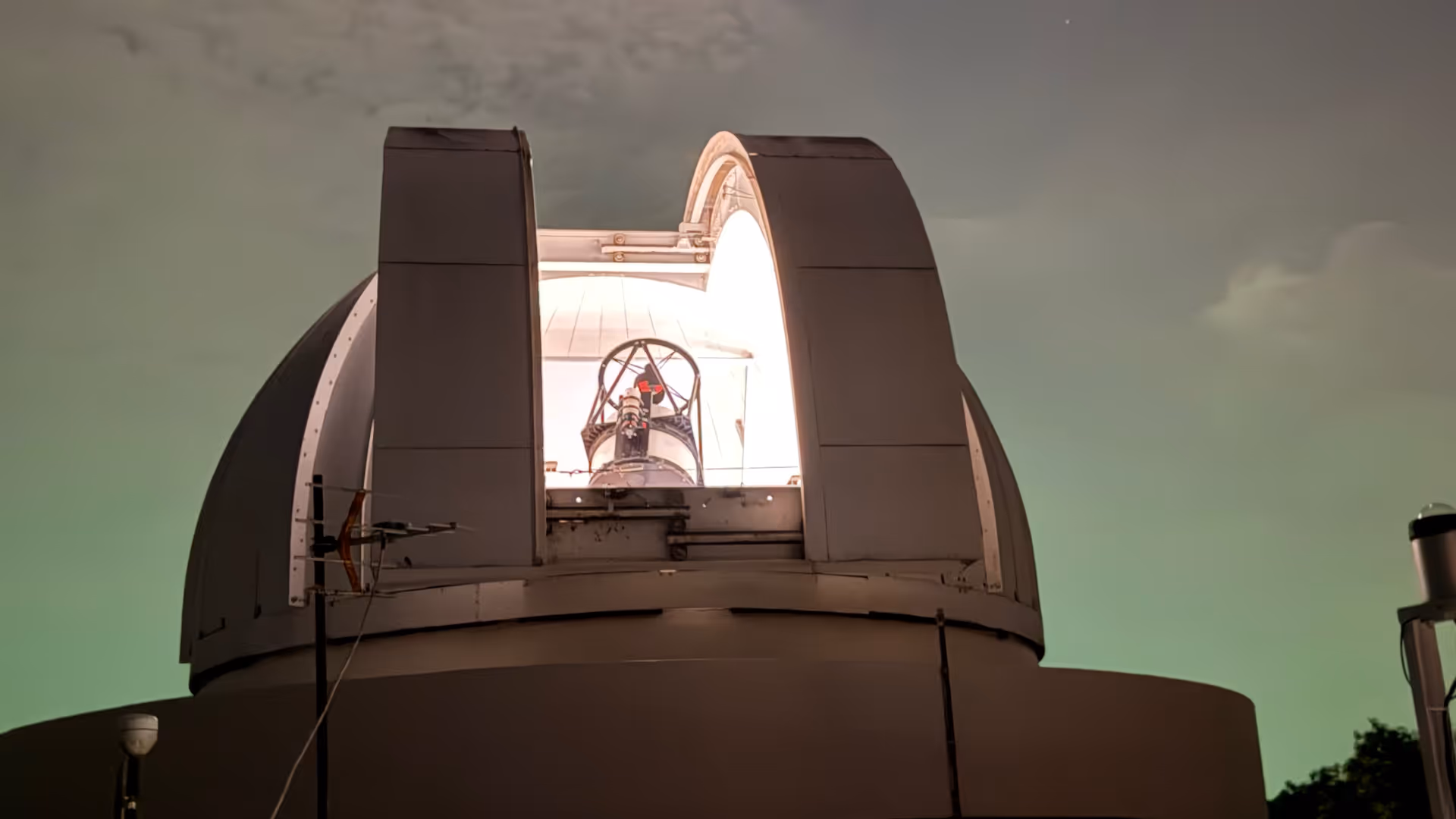 A massive scientific telescope inside the dark observatory, ready for a night of stargazing.
