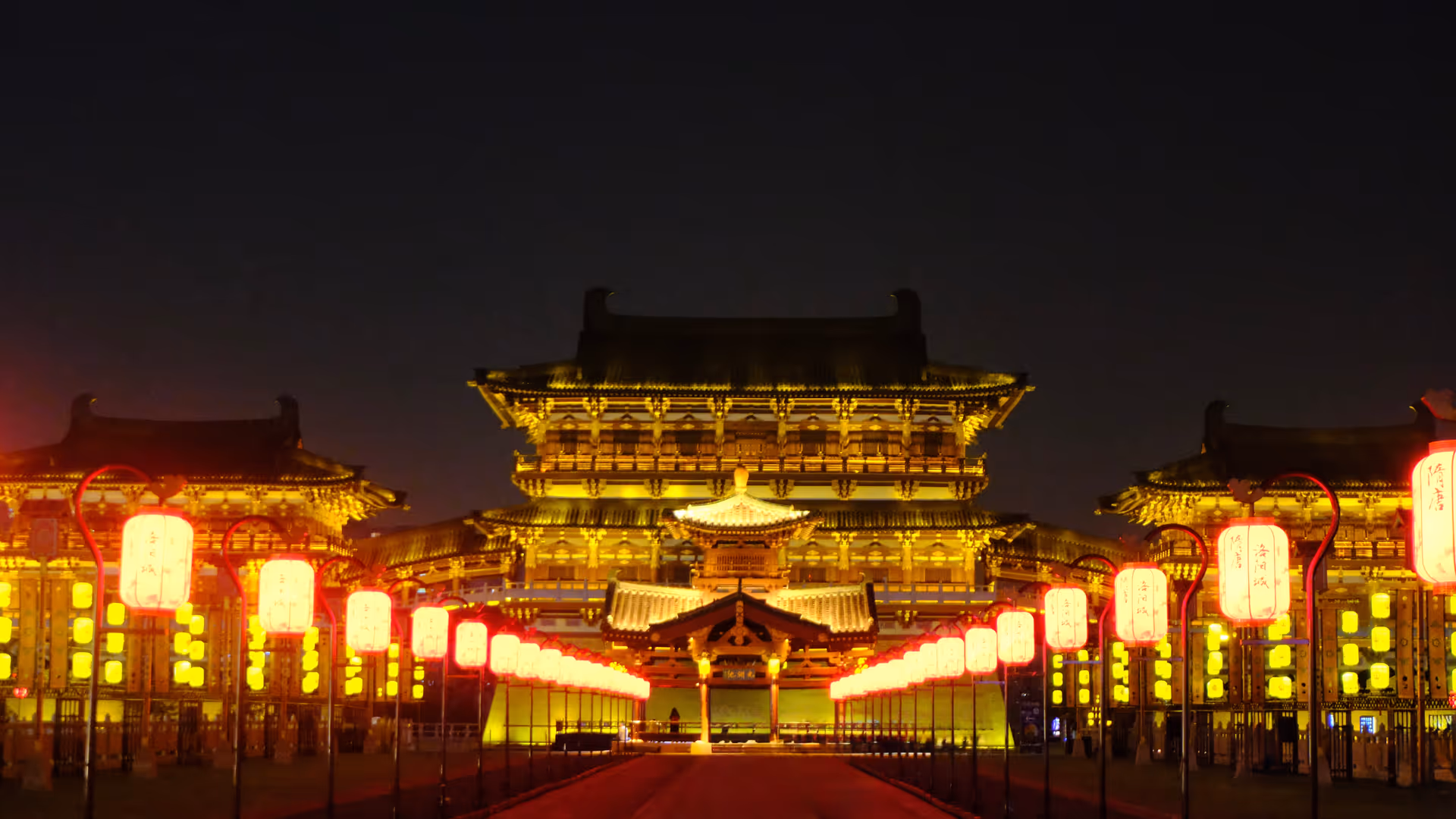 The grand Tang dynasty palace complex in Luoyang lit up at night, rows of red lanterns lining a wide ceremonial avenue.