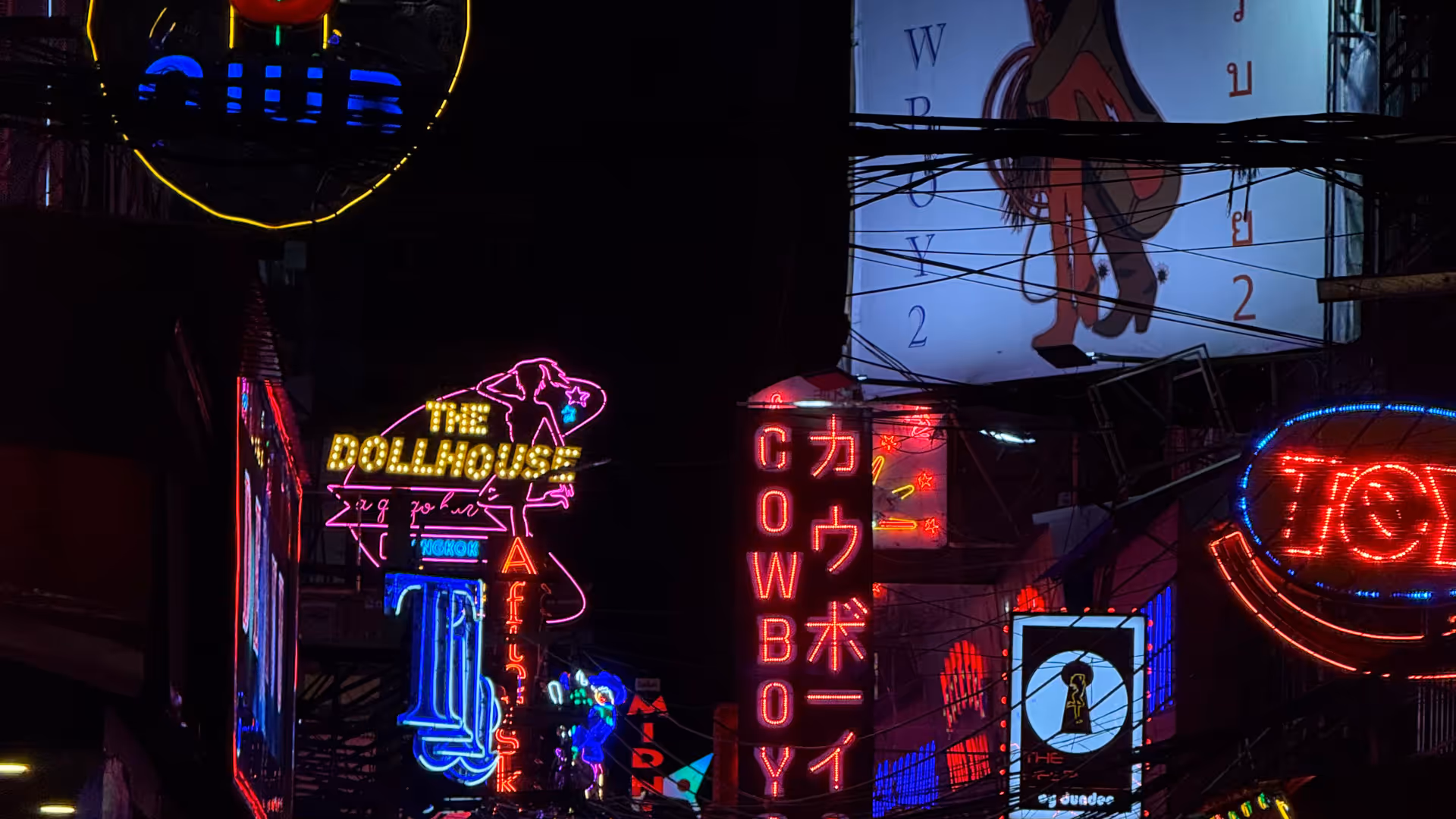 A cluster of bright, flashing neon signs in the Nana district at night.