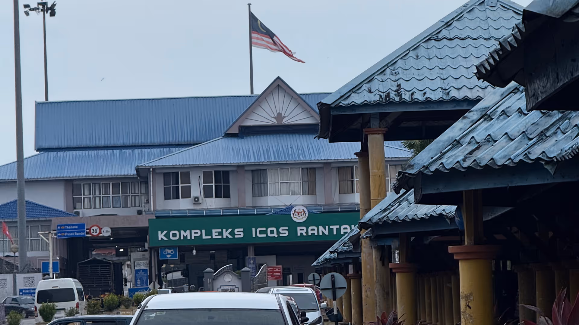 The Malaysian border complex at Rantau Panjang under a heavy, overcast sky.