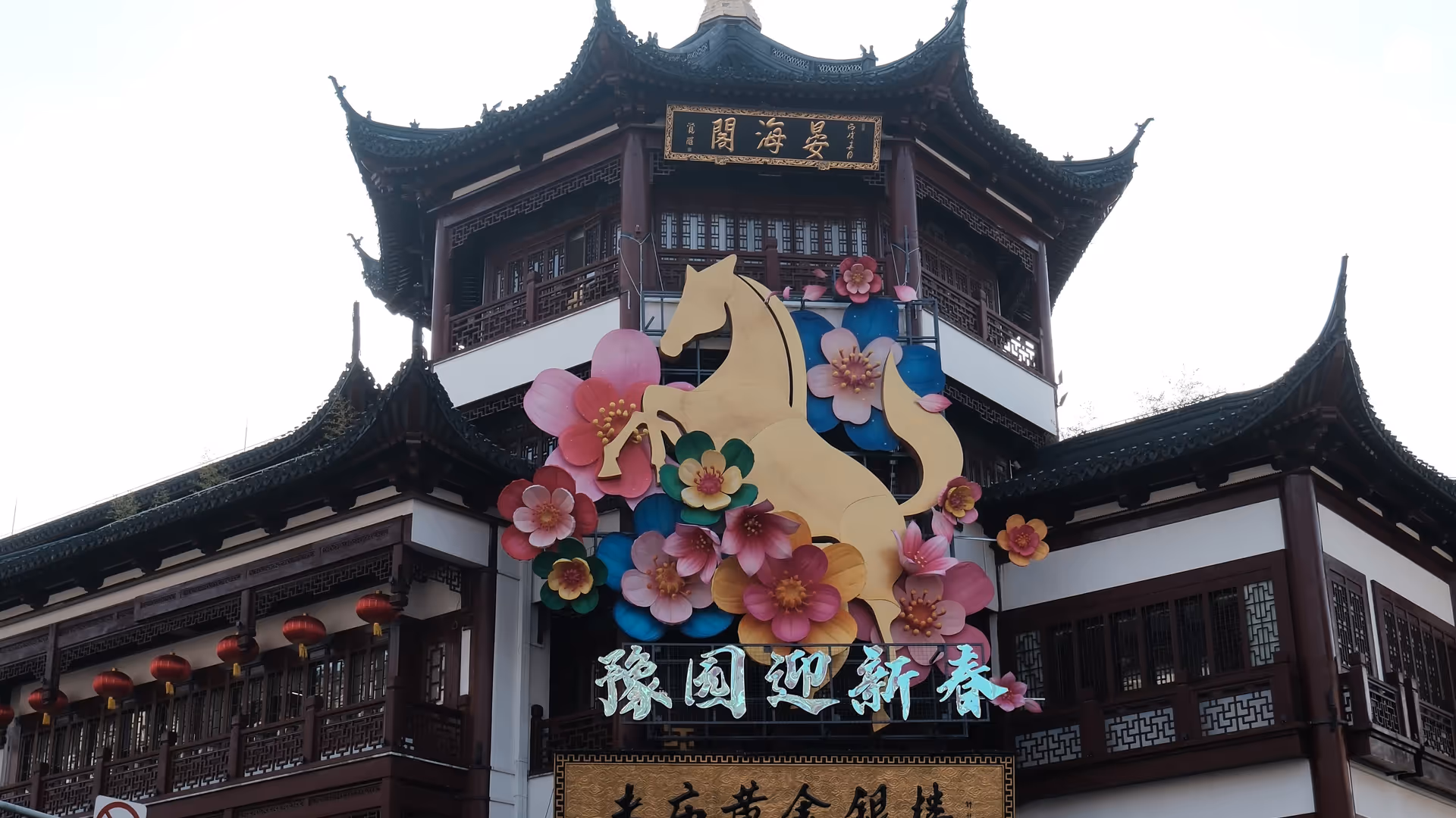 The Yu Garden bazaar entrance decorated with a large golden snake and flowers for the Chinese New Year.