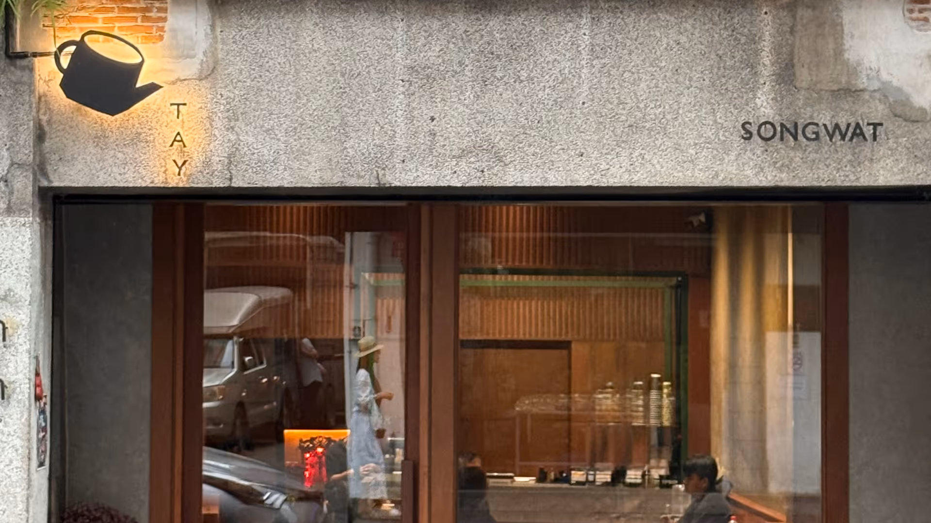 A minimalist cafe front on Song Wat road with a single red lantern.